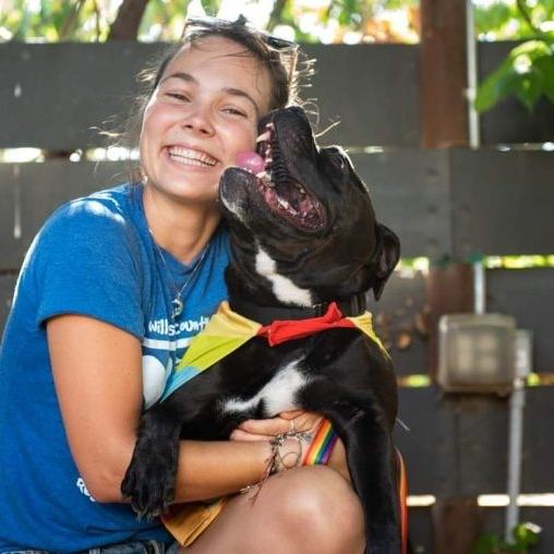 Korri Bindl, President of Furrbaby Food Pantry, holding a dog